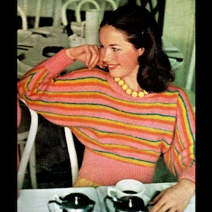 Puede incluir: Un suéter rosa con rayas horizontales en naranja, amarillo y verde. El suéter tiene mangas largas y cuello redondo. Se usa un collar de cuentas amarillas. La imagen es una fotografía de moda vintage.