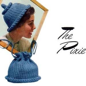 Puede incluir: Un gorro azul de ganchillo con una parte superior puntiaguda y una bolsa de cordón azul de ganchillo a juego. El gorro se muestra en la cabeza de una mujer en una foto enmarcada. El texto "The Pixie" está escrito en cursiva debajo de la foto.