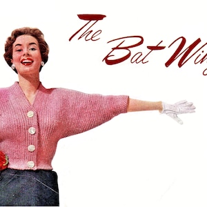 May include: A woman wearing a pink knitted cardigan with a batwing sleeve design. The cardigan has a V-neck and buttons down the front. The text "The Bat Wing" is written in red cursive above her head.