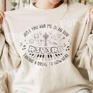 Peut inclure: Sweat-shirt crème avec un motif graphique noir. Le motif comprend le texte "JUST YOU AND ME IN AN SUV" et "R3V3RB TAKING A DRIVE TO NOWHERE", ainsi que des notes de musique, un microphone et d'autres icônes. Le sweat-shirt est de style décontracté.