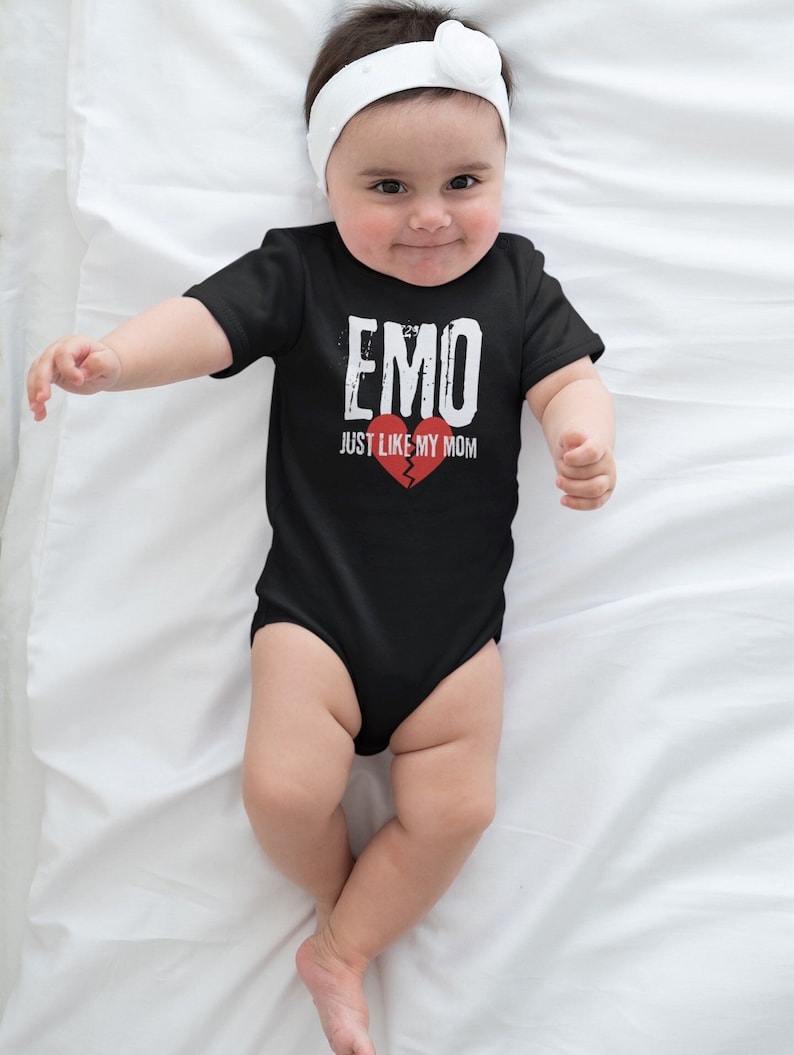 May include: A black baby onesie with white text that reads "EMO JUST LIKE MY MOM" and a broken red heart graphic.
