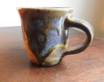 Coffee mug with runny blue glaze.