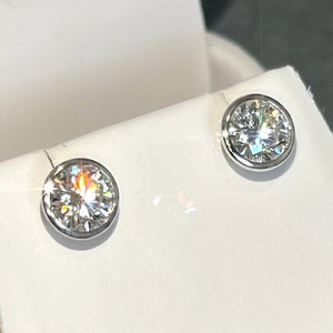 May include: A pair of silver stud earrings with clear round gemstones.