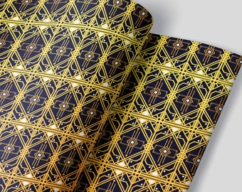 Puede incluir: Un rollo de papel estampado con un diseño geométrico repetitivo en oro y blanco sobre un fondo azul marino. El patrón presenta formas de diamante y elementos lineales, creando una estética vintage o art déco.