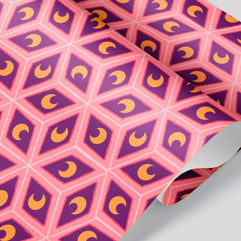 May include: Pink and white patterned wallpaper with a repeating geometric design. The pattern features purple diamond shapes with orange crescent moons inside. The wallpaper is rolled up, showing the pattern on the surface.
