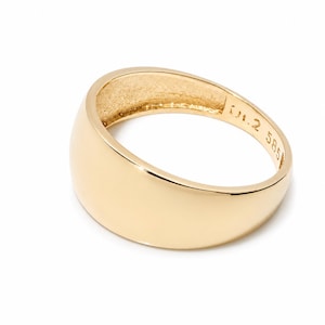 May include: A polished gold dome ring with a smooth, curved surface. The interior of the band features engraved markings that include the text 585, indicating the gold purity, along with other small, partially visible alphanumeric characters.