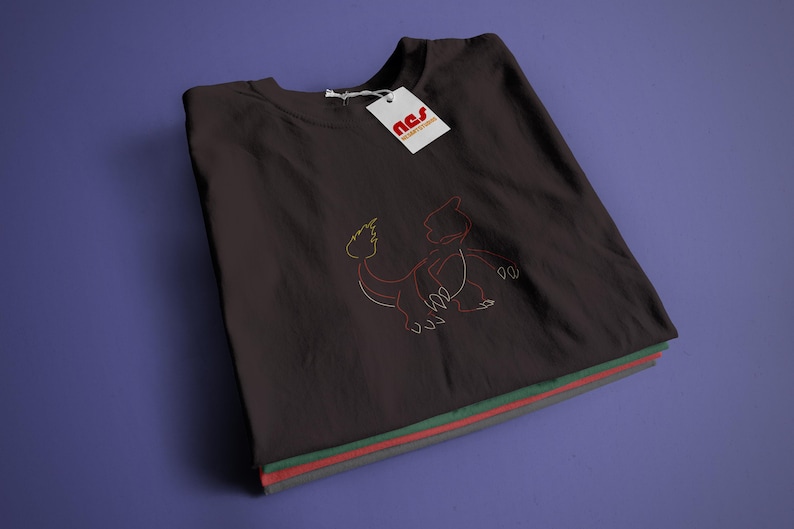 May include: A dark grey t-shirt with a red, yellow, and white embroidered design of a mythical creature. The shirt is folded and stacked with other shirts in green, red, and grey.