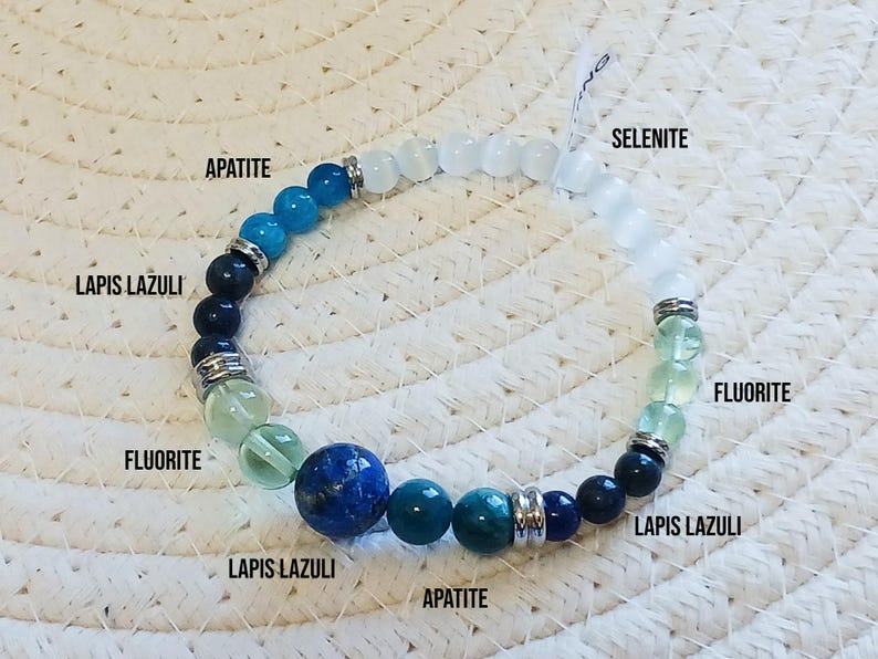 Pode incluir: Um bracelete feito com v&aacute;rias pedras preciosas, incluindo apatita, l&aacute;pis-laz&uacute;li, fluorita e selenite. O bracelete &eacute; feito com uma mistura de pedras azuis, verdes e brancas.