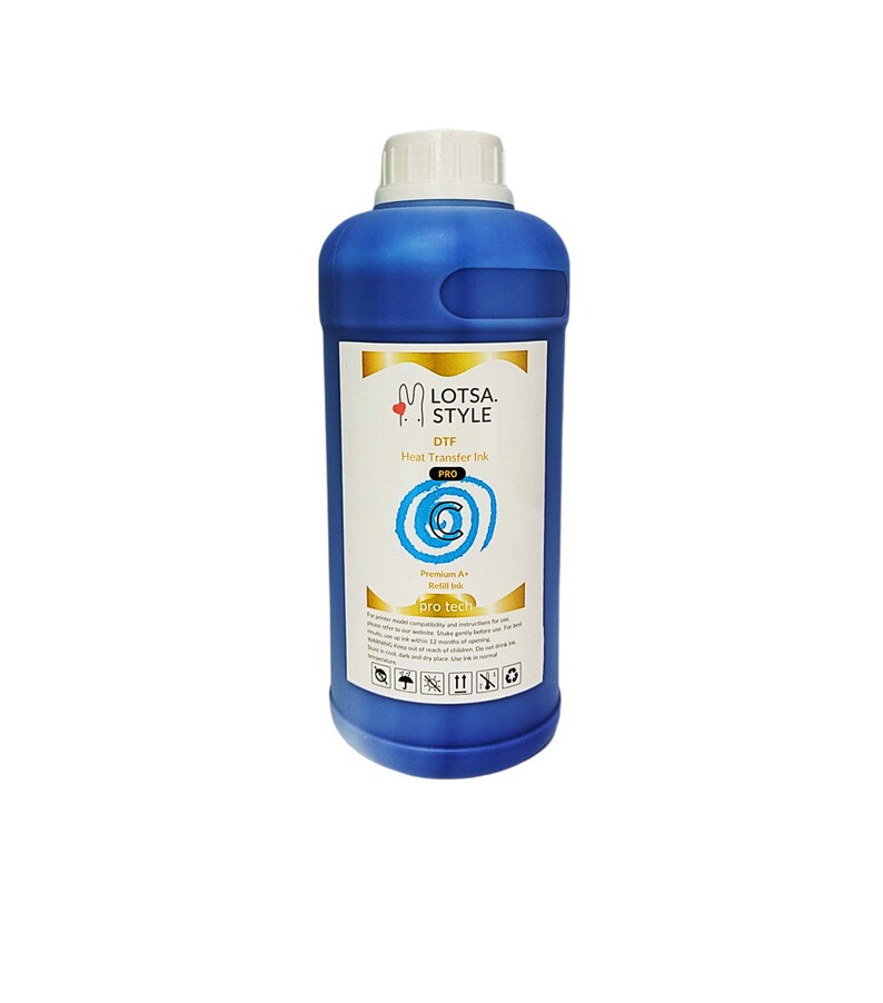 Op de afbeelding: Een blauwe fles Lotsa Style DTF Pro Heat Transfer Ink. De fles heeft een witte dop en een gouden etiket met de merknaam en productinformatie. Het etiket bevat ook een blauw spiraalontwerp en de tekst "Premium Art Refill Ink".
