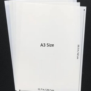 May include: A stack of white A3 size paper sheets, measuring 11.7 inches by 16.5 inches.