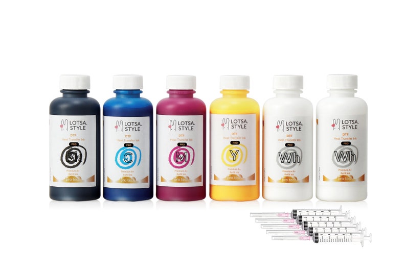 Op de afbeelding: Zes flessen hittetransferinkt in zwart, cyaan, magenta, geel en twee flessen witte inkt. De flessen zijn gelabeld "Lotsa Style DIY Heat Transfer Ink Pro". De inkt is bedoeld voor gebruik met een warmtepers. Zes spuiten zijn inbegrepen.