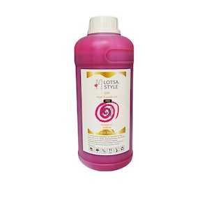 Op de afbeelding: Een roze fles Lotsa Style DTF Pro Heat Transfer Ink. De fles is voorzien van een etiket met de merknaam, productnaam en gebruiksaanwijzingen. De inkt is ontworpen voor gebruik met DTF-printers.