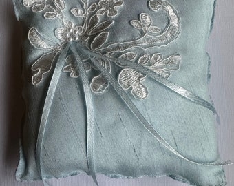 Blue faux silk Ring Pillow with ivory lace appliqués blue Ribbon ties and Bead details.