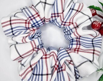 May include: White scrunchie with a red, blue, and black plaid pattern.