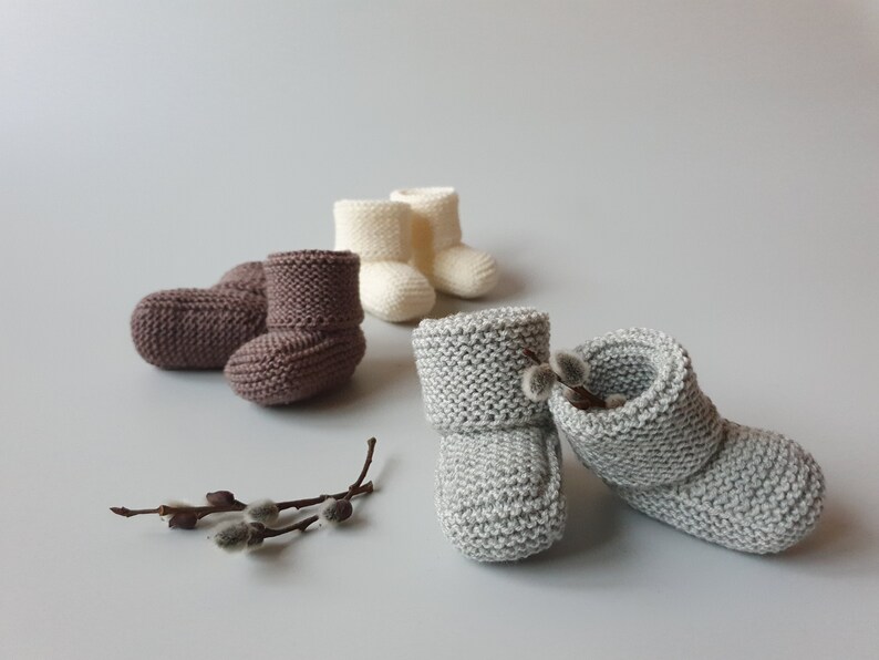 Three pairs of handmade children slippers in neutral colors - light gray which is the same tone as the poplars, dark beige - which is the same tone as the willow branches and off white.