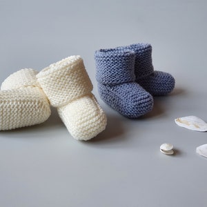 Two pairs of cute newborn baby booties in off white and lavender colors. Hand knitted in garter stitch from pure, soft merino wool.