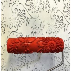 May include: Red paint roller with a floral design. The roller is used to create a textured pattern on walls.