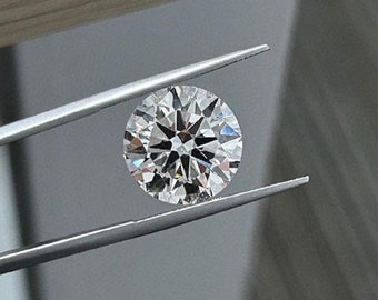 May include: A clear round diamond held by tweezers. The diamond is certified by the International Gemological Institute (IGI).