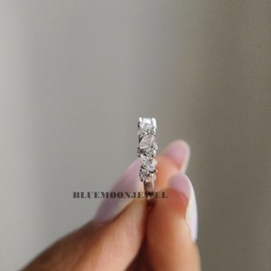 May include: A silver band ring with a row of marquise-shaped clear stones.