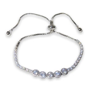 May include: A silver adjustable bracelet with a row of clear round cubic zirconia stones. The bracelet has a sliding knot closure.