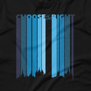 Op de afbeelding: Zwart t-shirt met de tekst "CHOOSE the RIGHT" in het wit. Het ontwerp heeft verticale blauwe strepen met een silhouet van een stadsgezicht aan de onderkant. De strepen hebben een gradiënteffect, van donkerblauw naar lichtblauw.