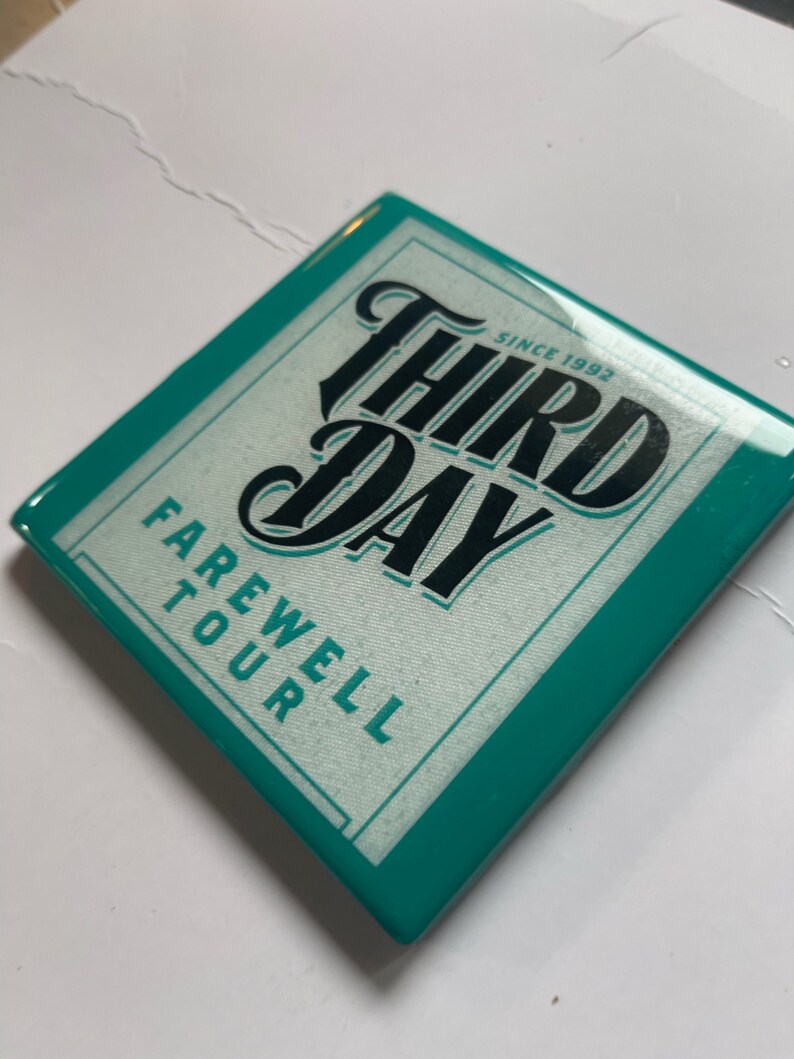 May include: Teal square coaster with a white background and black text that reads "Third Day" in a stylized font. The text "Since 1992" is above the band name and "Farewell Tour" is below the band name.