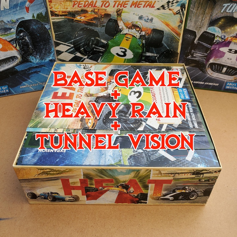 May include: A boxed board game set with the text "BASE GAME + HEAVY RAIN + TUNNEL VISION" in red. The box features vintage racing car illustrations and the words "PEDAL TO THE METAL" and "HEAT".