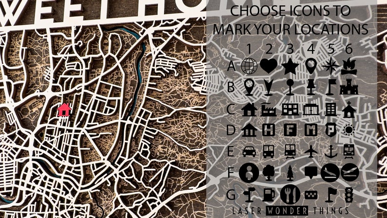May include: A laser-cut wooden map with a white outline of a city. The map has a red house icon in the center. On the right side of the map, there are icons to mark locations, labeled A through G and 1 through 6. The text "CHOOSE ICONS TO MARK YOUR LOCATIONS" is at the top of the icon section. The text "LASER WONDER THINGS" is at the bottom of the icon section.