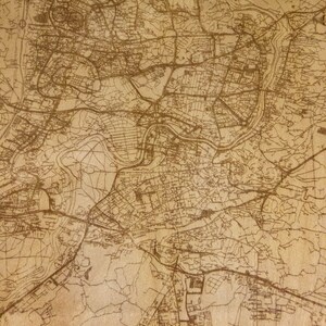 May include: A vintage-style map of Vilnius, Lithuania, with brown lines on a beige background. The map shows the city's streets and landmarks. The text "VILNIUS" is printed in a large, bold font at the bottom of the map. The text "LITHUANIA N54 41 40 90 E25 16 17 08" is printed in a smaller font below the city name.