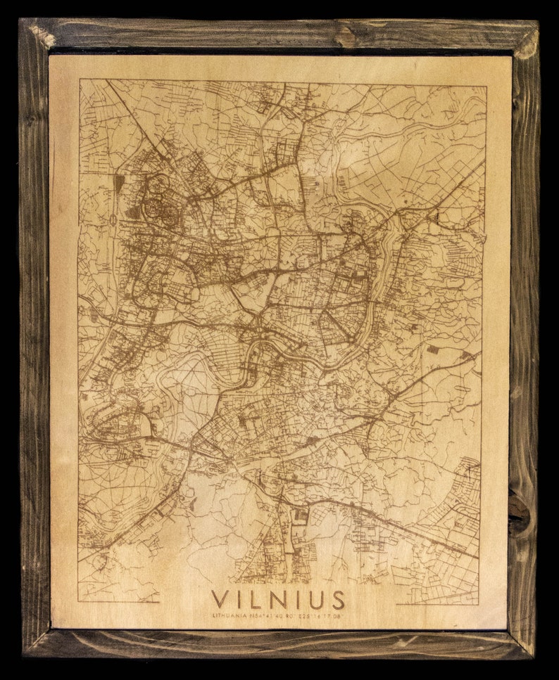 May include: A wooden framed map of Vilnius, Lithuania. The map is laser engraved on a light brown wood surface. The city name "VILNIUS" is printed in black at the bottom of the map.