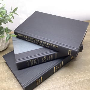 K&ouml;nnte beinhalten: Drei gebundene B&uuml;cher, die &uuml;bereinander gestapelt sind. Das oberste Buch ist schwarz mit goldenen Lettern, auf denen "Hillary Rodham Clinton Living History" steht. Das mittlere Buch ist schwarz mit goldenen Lettern, auf denen "Hard Call John McCain with Mark Salter" steht. Das unterste Buch ist schwarz mit goldenen Lettern, auf denen "Decision Points George W. Bush" steht.