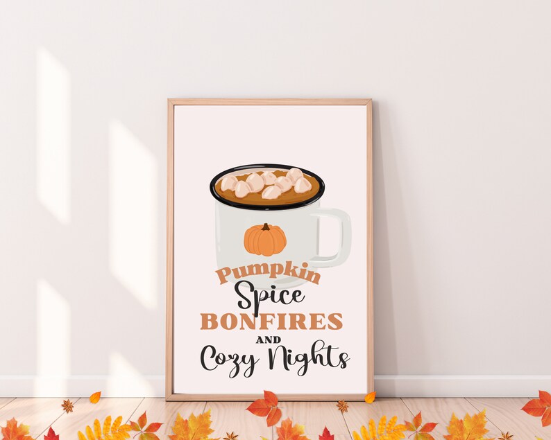 May include: A framed print featuring a white mug with a pumpkin graphic and a hot beverage topped with marshmallows. The text reads "Pumpkin Spice Bonfires and Cozy Nights" in a fall-themed design.