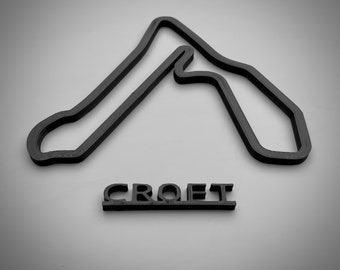 以下が含まれることがあります： クロフトサーキットのレーストラックの黒色の3Dプリントモデルで、下に「CROFT」という文字が印刷されています。