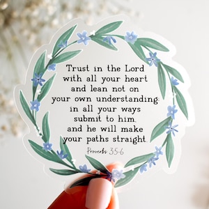 May include: A clear sticker with a floral wreath design and the text "Trust in the Lord with all your heart and lean not on your own understanding: in all your ways submit to him. and he will make your paths straight. Proverbs 3:5-6"