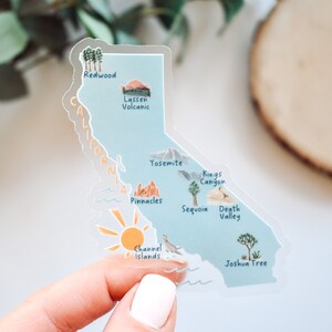 May include: A clear sticker featuring a map of California, highlighting various national parks and landmarks. The sticker includes the names "Redwood", "Lassen Volcanic", "Yosemite", "Kings Canyon", "Sequoia", "Death Valley", "Pinnacles", "Channel Islands", and "Joshua Tree".