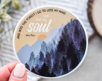 May include: A round sticker with a quote by John Muir: "And into the forest I go to lose my mind and find my soul." The sticker features a watercolor-style illustration of a forest with a sunset in the background.