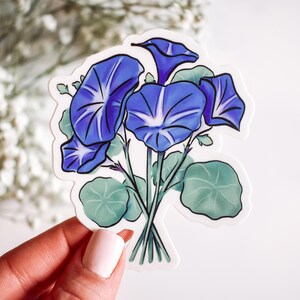 May include: A sticker featuring a bouquet of blue morning glory flowers with green leaves. The flowers are drawn in a stylized, watercolor-like style.
