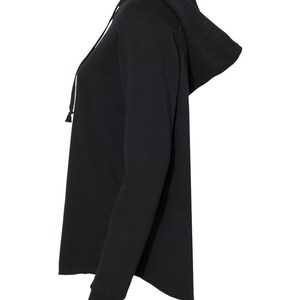a woman wearing a black hoodie with a zipper