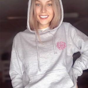 a woman with blonde hair wearing a gray hoodie