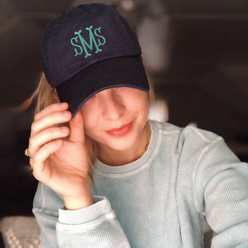 a woman wearing a hat with a monogrammed hat on top of her head