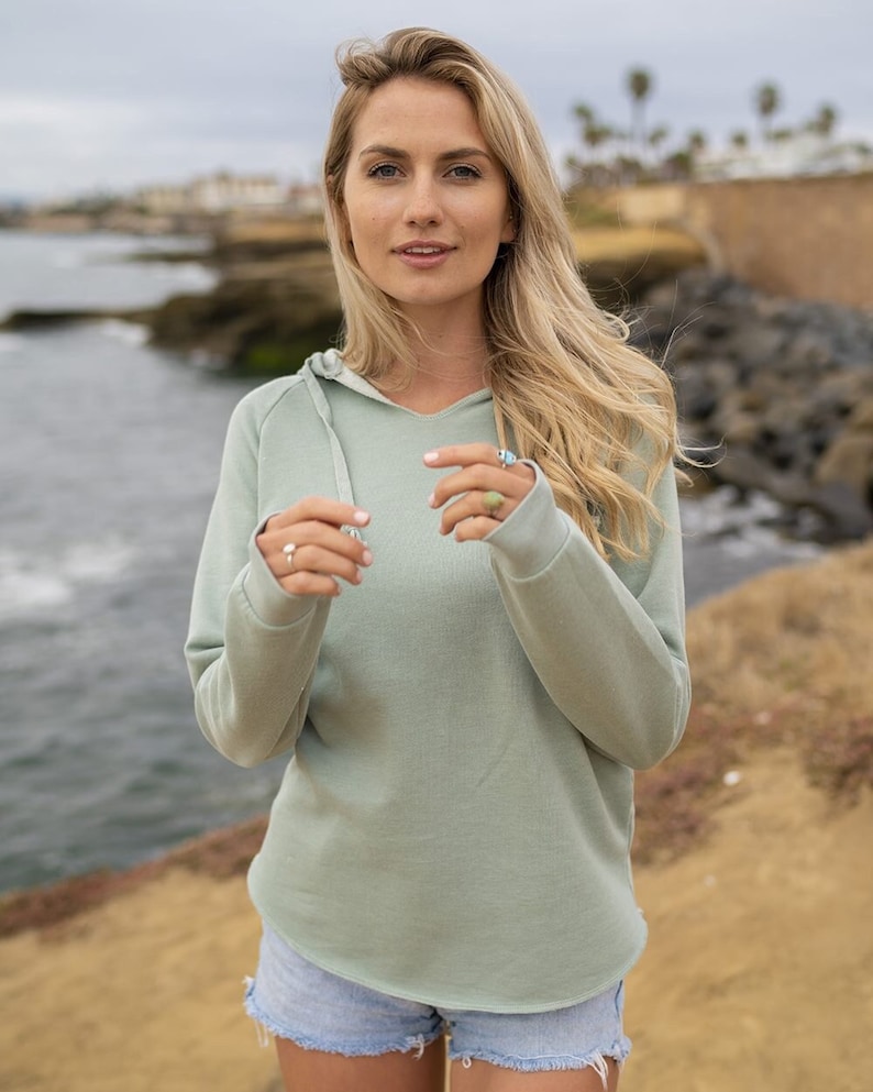 a beautiful blond woman standing on top of a cliff
