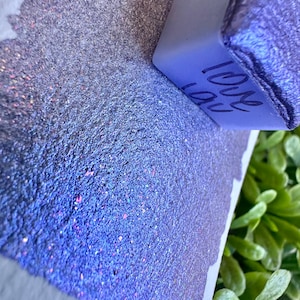 May include: A purple glitter with a small cube that says "I love you" on it.