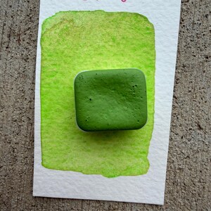 May include: A watercolor painting on white paper with a bright green wash and a textured, square, dark green paint block. The words "VIP ENTRY" are written in pink ink at the top of the paper.