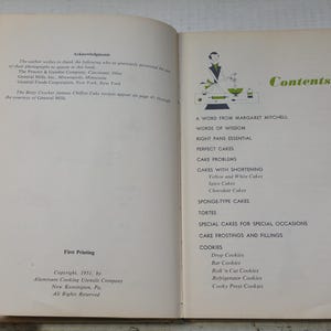 May include: Open vintage cookbook with a contents page featuring a green and white illustration. The table of contents lists cake recipes, including spice cakes and chocolate cakes, and cookie recipes.