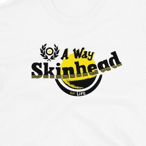 May include: White t-shirt with a black and yellow graphic that says "A Way of Life Skinhead".