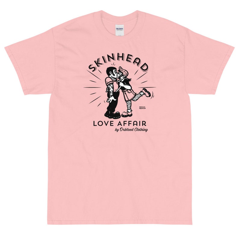 May include: A pink t-shirt with a black and white illustration of a couple kissing. The illustration is surrounded by a circle with the text "SKINHEAD LOVE AFFAIR by Orblood Clothing".