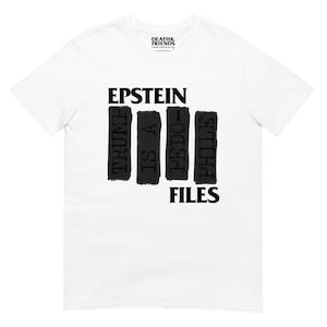 Może przedstawiać: Biały t-shirt z krótkim rękawem z czarnym nadrukiem graficznym na klatce piersiowej. Tekst brzmi EPSTEIN TRUMP IS A PEDO-PHILE FILES, a słowa są ułożone w cztery pionowe czarne prostokątne bloki. Etykieta marki zawiera napis DEATH & FRIENDS.