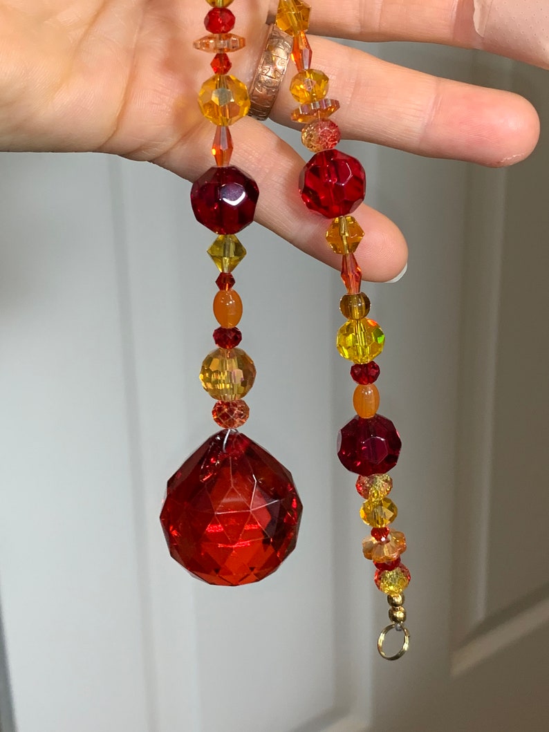 Suncatcher with red drop focal crystal yellows Hand strung reds oranges