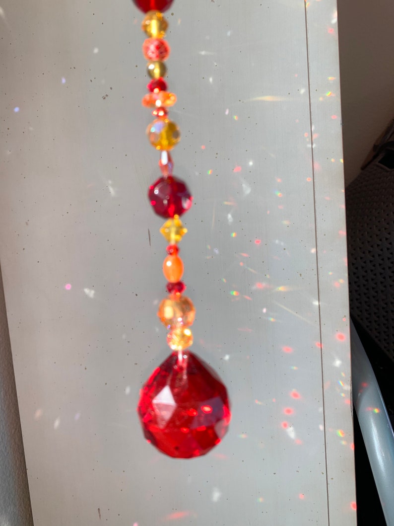 Suncatcher with red drop focal crystal yellows Hand strung reds oranges