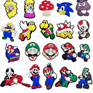 May include: A set of 20 colorful cartoon character shoe charms featuring characters from the Super Mario Bros. video game franchise, including Mario, Luigi, Princess Peach, Toad, Bowser, and more.